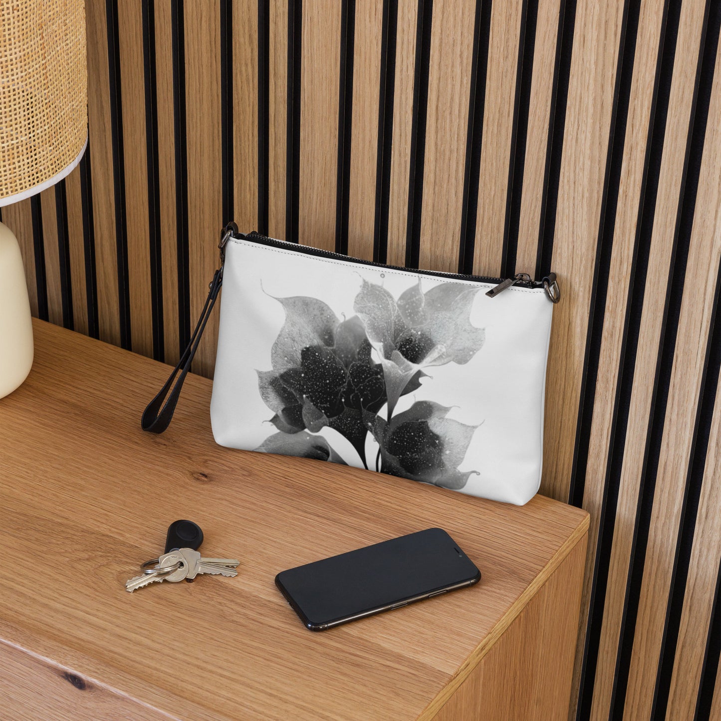 Accessoire femme chic, sac en bandoulière floral noir et blanc avec dragonne amovible.